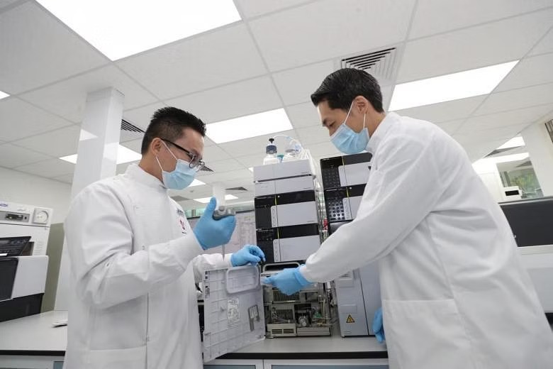  ​Dr Daryl Hee (left) and clinical assistant professor Troy Puar operate the liquid chromatography tandem mass spectrometer. ST PHOTO TIMOTHY DAVID 