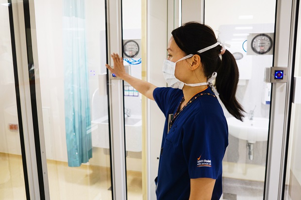  ​Dr Tan Zihui, Associate Consultant, Department of Anaesthesiology, SGH, enters an ICU fitted with the SG-SPARC system through no-touch motion sensor doors. These doors are a unique feature of the SG-SPARC.